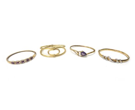 A 9ct gold oval hinged bangle, the front with a serpentine motif, a gold oval bangle, mounted with a pear shaped amethyst, de