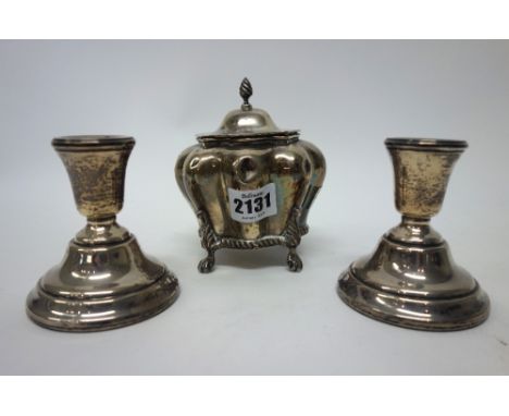 Silver, comprising; a hinge lidded tea caddy, of bombe shaped form, the lid with a wrythen knop finial and raised on four paw