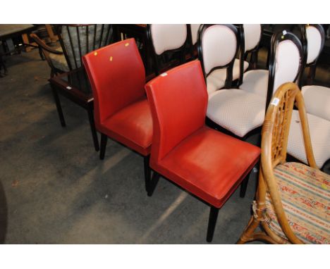 A pair of red upholstered vintage chairs