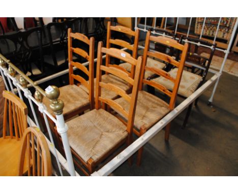 A set of four rush seated and ladder back pine dining chairs