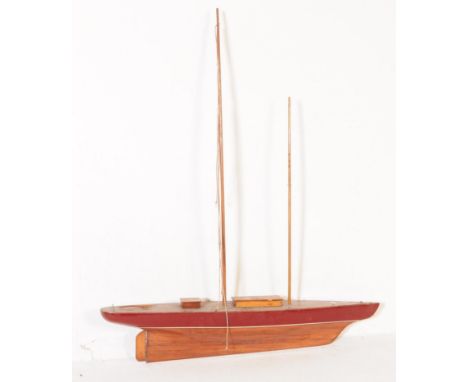 A vintage 20th century pond model boat / yacht. Having two masts with red colourway, wooden hull with rudder to rear. Measure