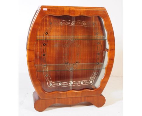 A vintage 20th century circa. 1950s walnut display cabinet. The cabinet of rounded form with glazed window front, featuring t