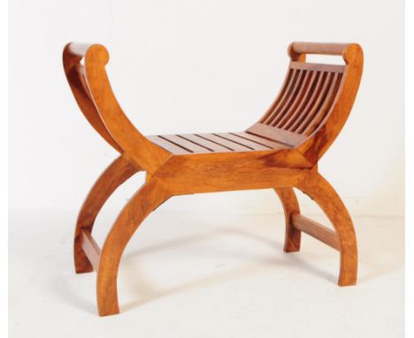 A contemporary Savonarola piano stool / bench. Having arched side for elbow rests, with slatted frame on on arched feet with 