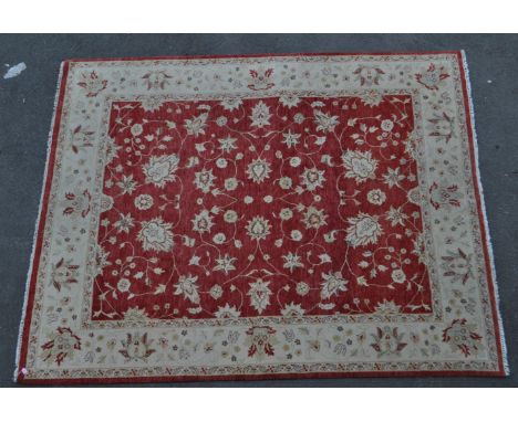 A vintage 20th century English carpet floor rug. With floral and foliate design to main body, with a cream and red ground and