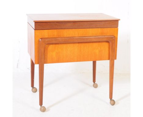 British Modern Design - A mid 20th century teak wood drinks trolley / sewing box cabinet. Raised on shaped tapered supports t