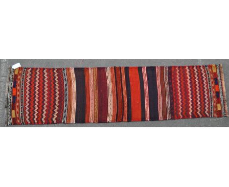 A vintage 20th century North West Persian Sumak kilim carpet floor rug. With repeating striped body with tassels to end. Meas