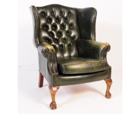 A 20th century green leather chesterfield manner wingback armchair. The chair having cabriole legs to front upon carved claw 