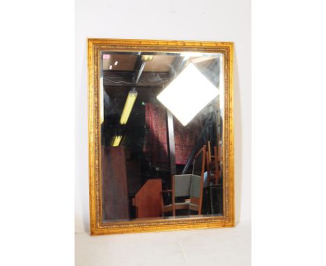 A contemporary gilt sprayed over mantel mirror. Rectangular form with repeating floral pattern to outer border. Bevelled edge