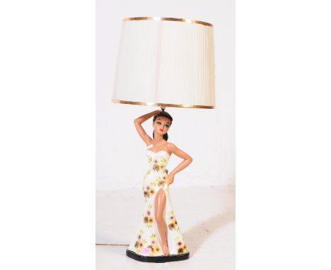 A mid 20th century Hawaiian lady hula dancer ceramic table lamp. The lamp having a cream fluted conical fabric shade, raised 