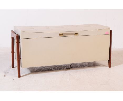 A retro mid 20th century white vinyl ottoman. The ottoman raised on teak wood legs to either side. Having a white rectangular