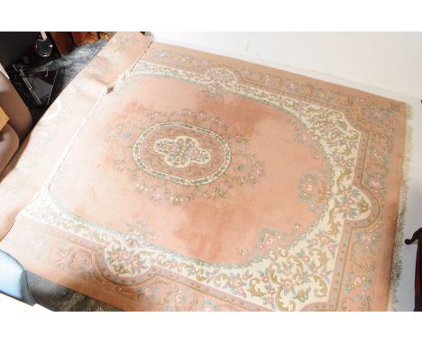 A large vintage 20th century Chinese carpet floor rug. Rectangular form with pastel colours in a red / brown ground. Central 