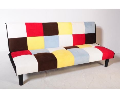 A contemporary fold down sofa klik klak bed / sofa settee. Of patch work design with colour blocks. Raised on ebonised metal 