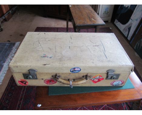 A vintage suitcase bearing travel labels and an army box