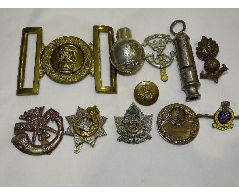 A Gibraltar brass military belt buckle, a Queen's Regiment silver and enamel sweetheart brooch, five military badges and othe