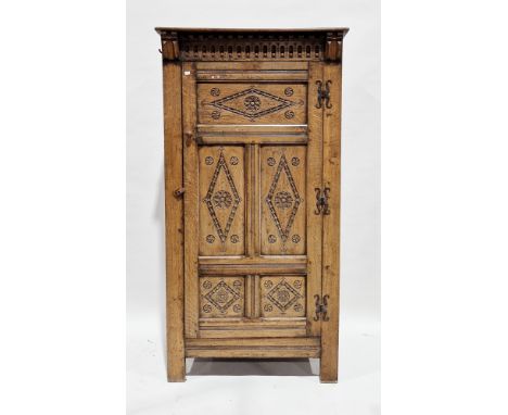 Jacobean Revival oak hall cupboard, the moulded pediment with nulling carving, the single panel door with carved motifs openi