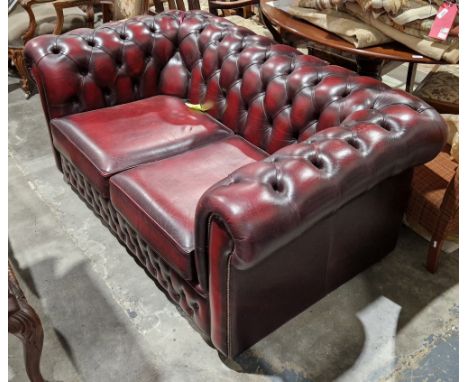 Victorian-style Chesterfield two-seater sofa upholstered in oxblood red button back leather with two padded cushions, 70cm hi
