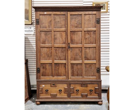 Jacobean revival oak and elm cupboard, the carved moulded pediment over two square panelled doors opening to a space holding 