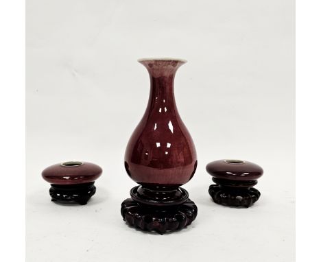 Chinese Qing Dynasty flambe sang-de-boeuf ground bottle-shaped vase and two brush washers, on carved hardwood stands (3) (hai