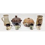 Four studio pottery terracotta and other mugs, two covered casseroles, jug and covered storage jar