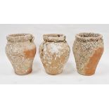 Set of three terracotta jars with integral holes for rope handles and bearing encrustation, 30cm