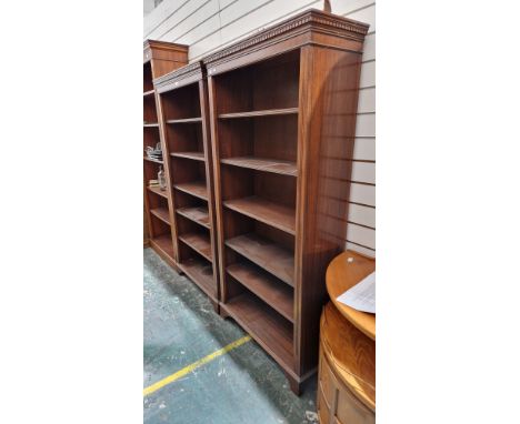 Pair of modern mahogany bookcases in the Regency manner with moulded dentil pediments, five adjustable shelves and raised on 
