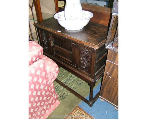 A reproduction Oak Cabinet on stand, the two plank top having moulded edge, two plank sides and the front having central two 
