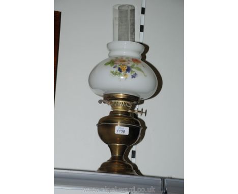 A Brass Oil Lamp with white Shade having floral pattern, and clear chimney