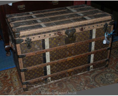 A large and well-travelled Louis Vuitton Travel Trunk, the edges with tooled leather and having wooden protective rubbing str