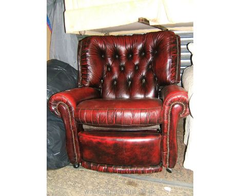 A modern deep red Leather button back reclining Armchair with scroll arms and nailed upholstery.