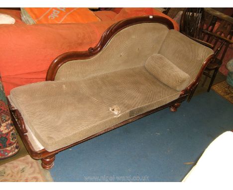 A Victorian Mahogany Chaise Longue with carved shaped back with button upholstery, carved scroll end arm, on moulded frieze w