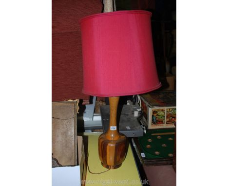 A wooden based Table Lamp with red coloured lampshade