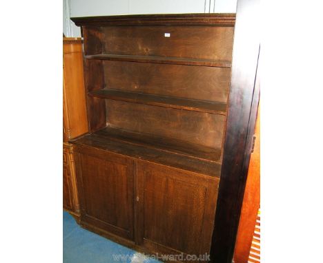 A stained exotic hardwood Bookcase on Cupboard having moulded cornice over the open back with two fixed shelves, the base hav