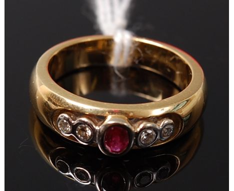 An 18ct gold, ruby and diamond ring, arranged as an illusion set oval cut ruby flanked to either side with a pair of graduate