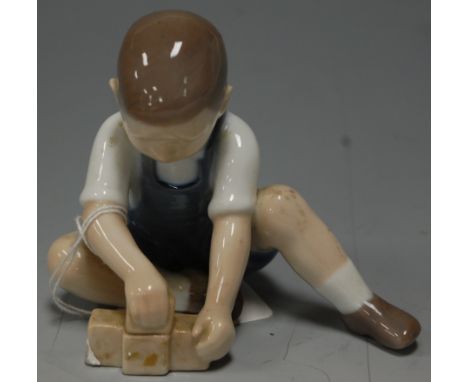 *A Bing & Grondhal porcelain figure of a young boy playing with bricks