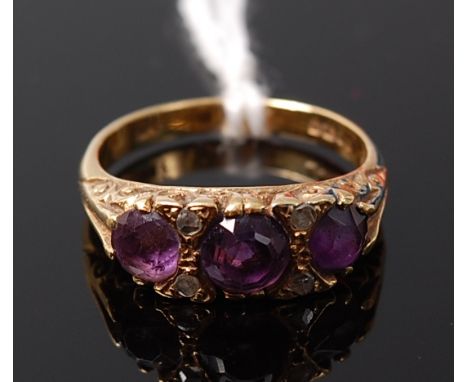 A circa 1900 18ct gold amethyst three stone ring further set with two pairs of diamond points, 5.1g, size N