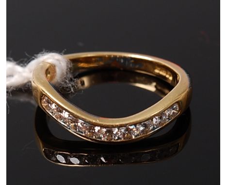 An 18ct gold and diamond set wishbone ring arranged as nine channel set brilliants, total diamond weight estimated approx. 0.