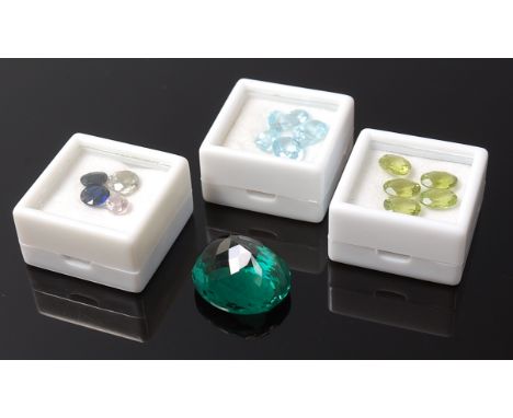 An oval cut loose green amethyst of good size together with other loose semi precious gemstones to include aquamarine, topaz,