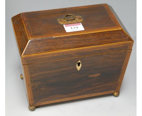 *A late Regency rosewood and crossbanded tea caddy of sarcophagus form having twin compartment interior and raised on brass b