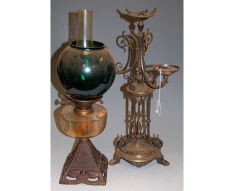An early 20th century oil lamp having green glass spherical shade to a clear glass reservoir on a cast base together with a 1