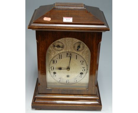 An early 20th century continental walnut cased bracket clock having an engraved arched dial with matt chapter ring and Arabic