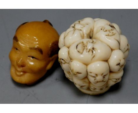 A reproduction netsuke carved in the form a mans head; together with parasol handle carved with faces (2) 