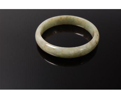 A Chinese jade bangle having russet inclusions 42.8g, dia. 7cm