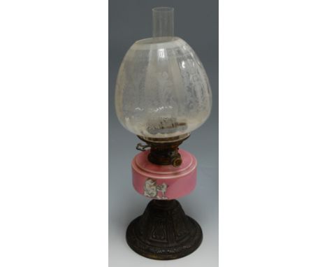 A Victorian pedestal oil lamp having etched globular glass shade, and pink reservoir with transfer decoration on brass base