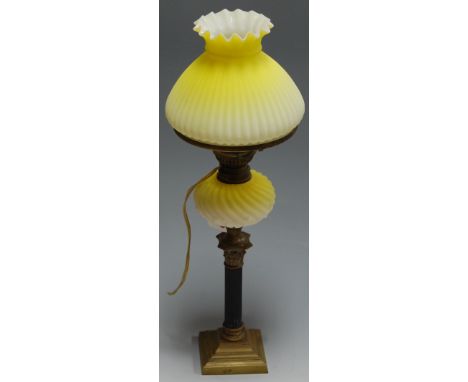 A 19th century oil lamp having a yellow tinted glass shade above a swirled glass reservoir on a Corinthian column to a steppe