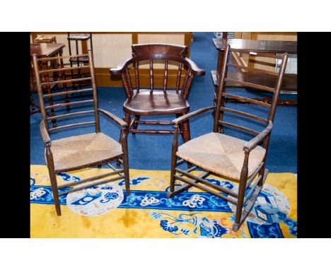 A Pair Of Lancashire Ladder back Chairs comprising armchair and rocker with traditional rush seats. Along with a stained wood