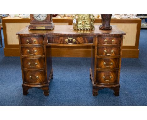 A Serpentine Fronted Pedestal Desk Comprising central drawer between two banks of four graduating drawers. Raised on bracket 