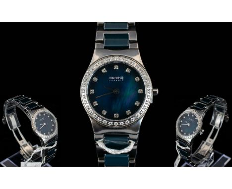 Ladies Cased Bering Ceramic Swarovski Crystal Bezel Set Ultra Slim Wrist Watch with push button deployment clasp. Features bl