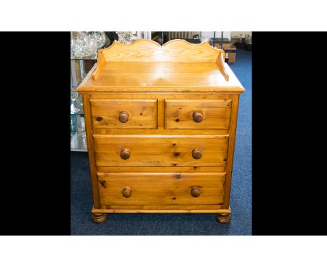 A Pine Chest Of Drawers raised on bobbin feet, two drawers over two long drawers with carved gallery top. Height 35 inches, 2