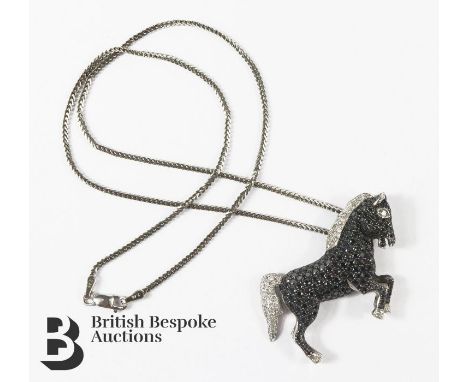 18ct white gold black and white diamond equine pendant. The horse set with 35 pts of white dias and 2cts of black dias, 40 x 
