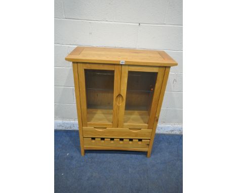A SOLID OAK CABINET, with double glazed doors, enclosing a glass shelf, above two drawers, the bottom drawer made to hold six